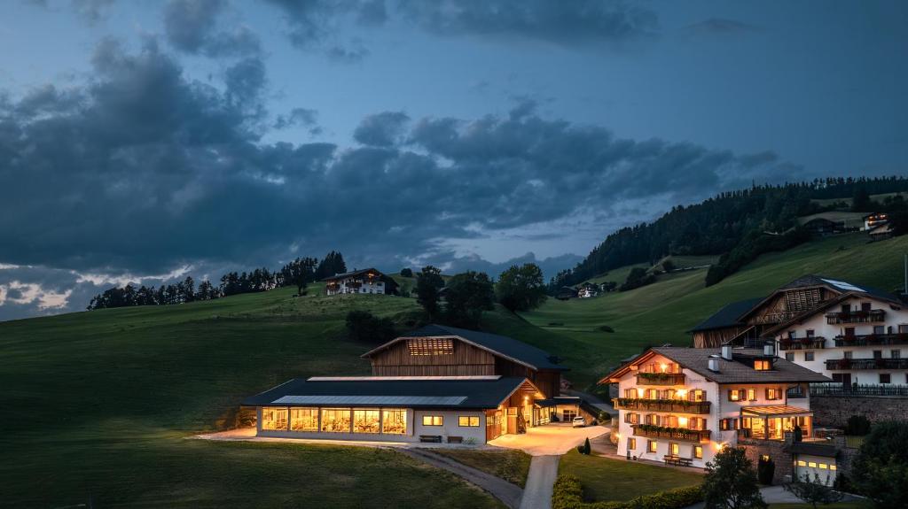 een groot huis op een grasheuvel 's nachts bij Formsunhof in Siusi