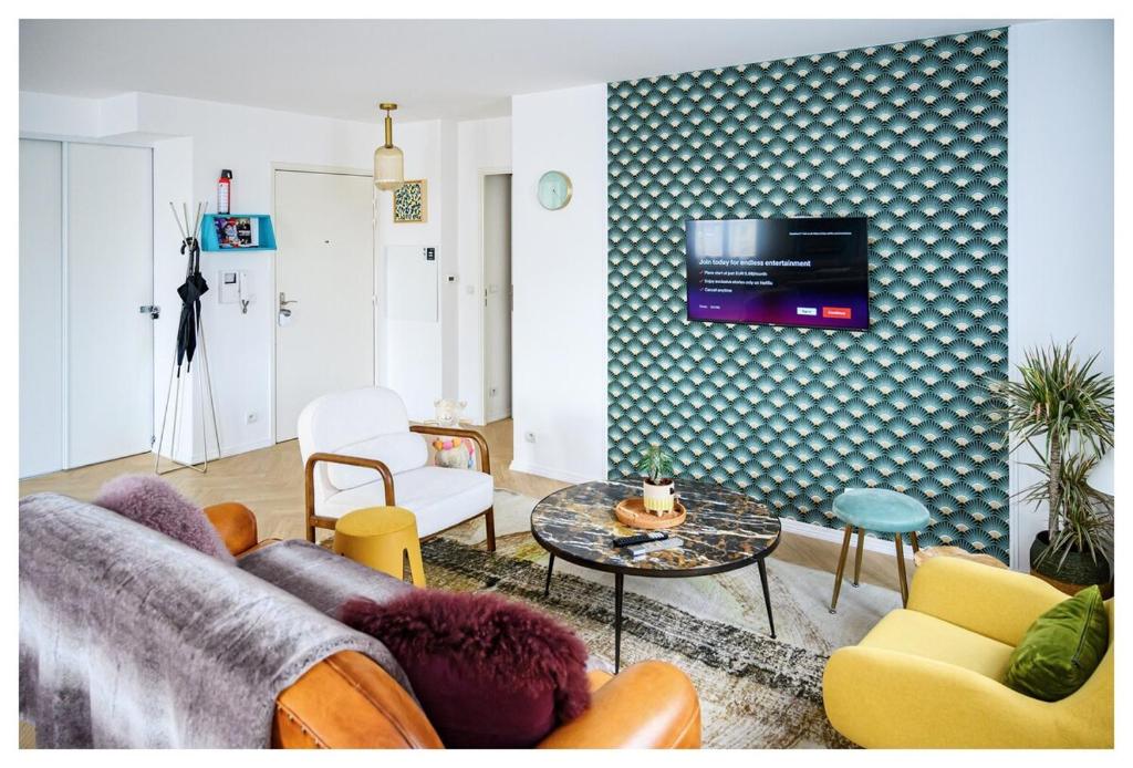 un salon avec un canapé et une télévision sur un mur dans l'établissement Super appart entre Disney et Paris avec parking !, à Bailly-Romainvilliers
