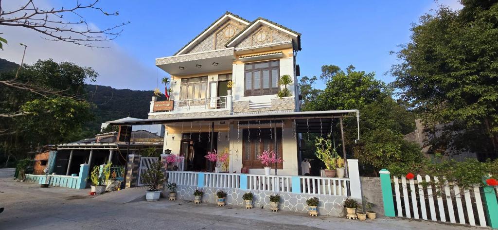 a house with a white fence in front of it at Hạnh Phương homestay in Tân Hiệp