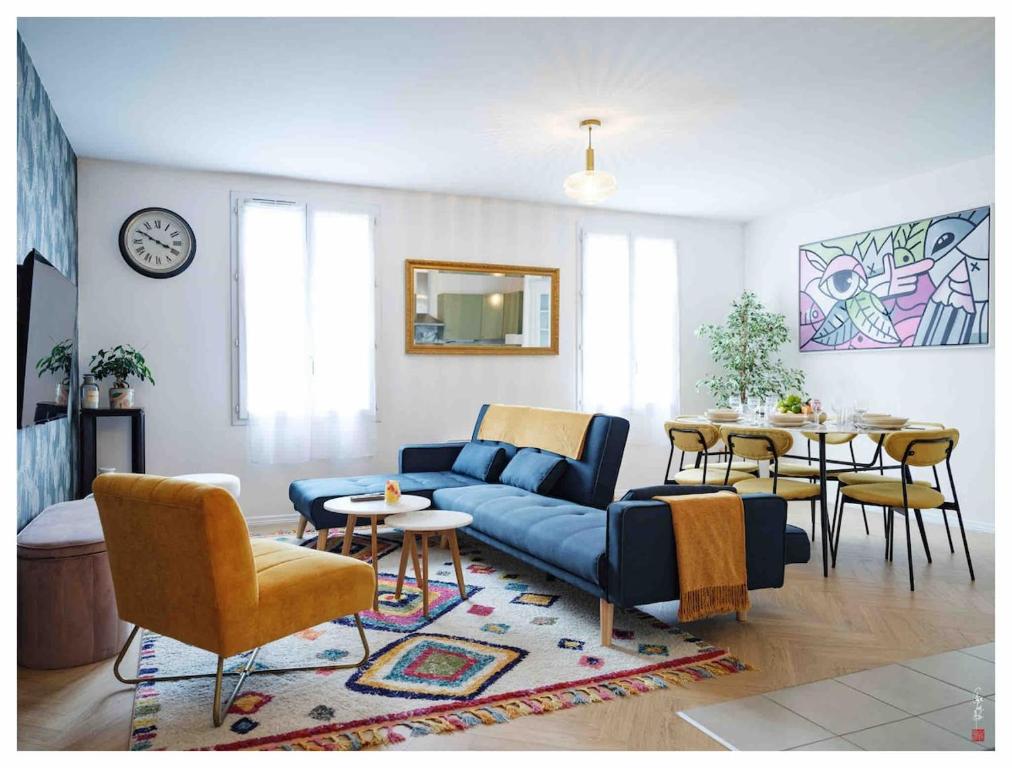 Una sala de estar con un sofá azul y una mesa. en Magnifique 3 étoiles 10 min de Disney et 40 min de Paris, en Bailly-Romainvilliers