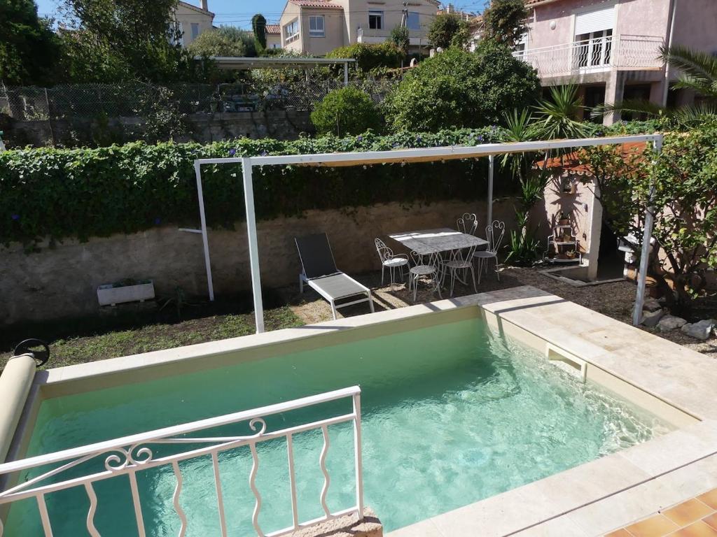 - une petite piscine avec une table et des chaises dans l'arrière-cour dans l'établissement maison de famille, 5mn du vieux port, calme absolu, à La Ciotat