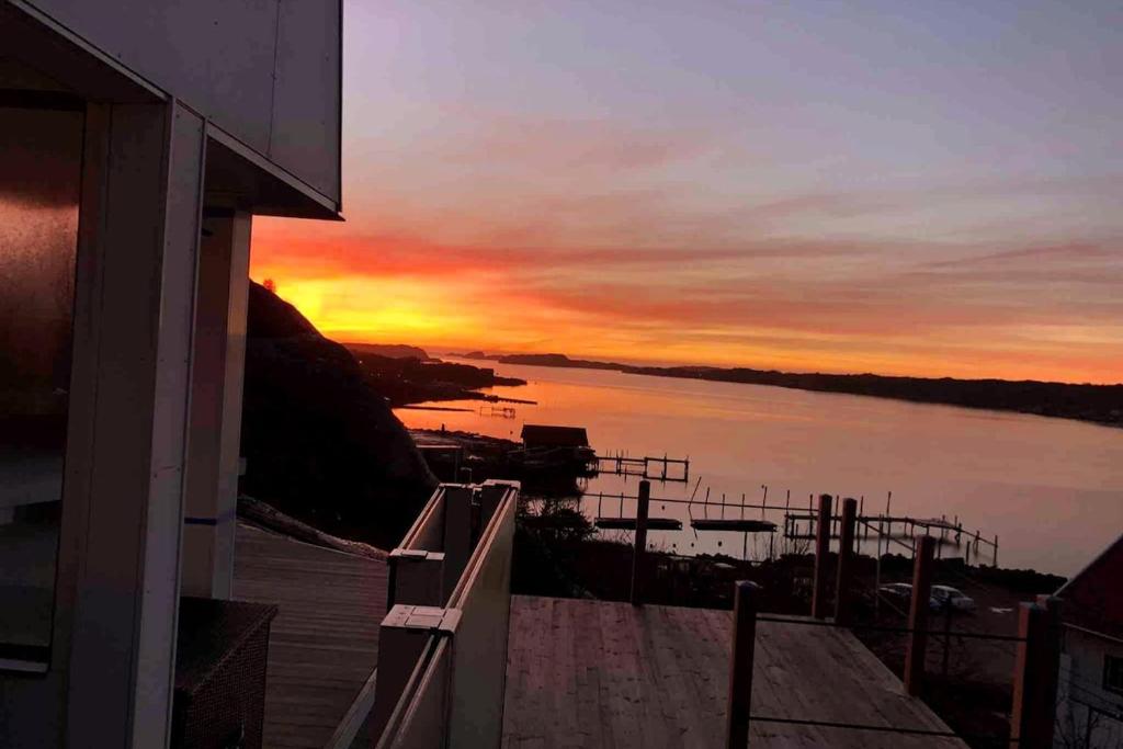 a sunset over a body of water with a building at Magical premium home in the best location in Bovallstrand