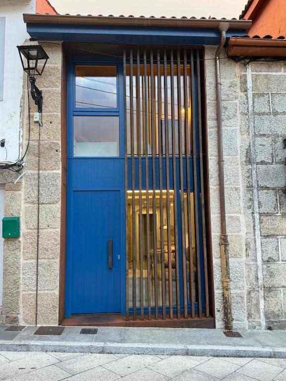 a blue door on a building with a window at Casa a Xanela Azul in Celanova