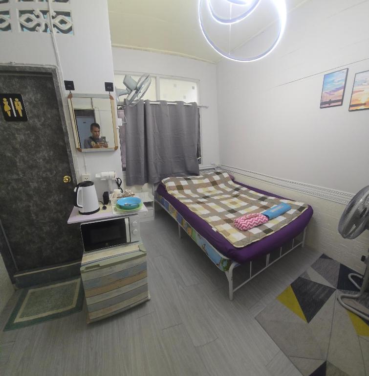 a small bedroom with a bed and a mirror at 103 Olan Place Apartment with fan and near SkyTrain and free Wi-Fi in Bangkok