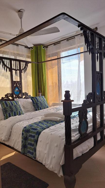 a bedroom with a large bed with a wooden frame at Casa Marabella in Diani Beach