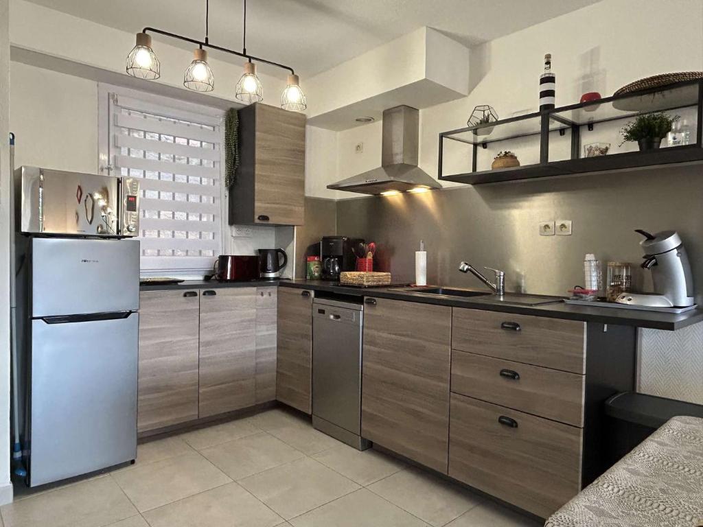 Il comprend une cuisine équipée d'appareils électroménagers en acier inoxydable et d'un réfrigérateur blanc. dans l'établissement Appartement 3 pièces 4 couchages BANYULS SUR MER BN330-037, à Banyuls-sur-Mer