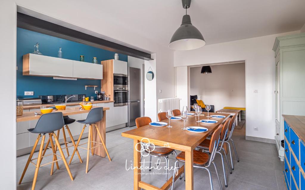 une cuisine avec une grande table et des chaises en bois dans l'établissement Évasion au Mans - Terrasse & Garage - L'Instant Clef, au Mans