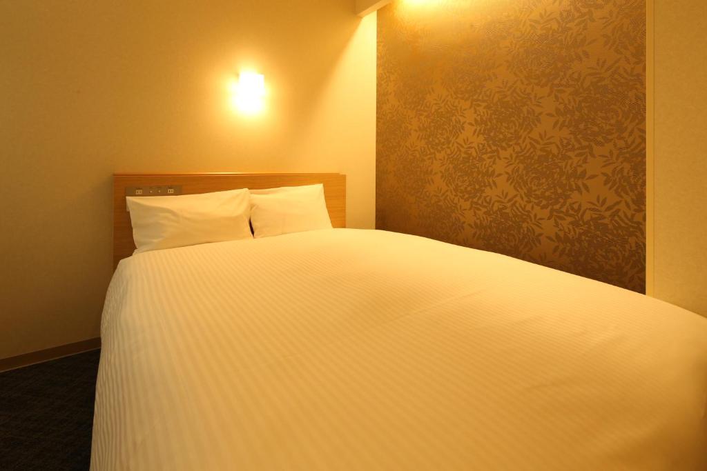 Postel nebo postele na pokoji v ubytování AB Hotel Sakaihigashi
