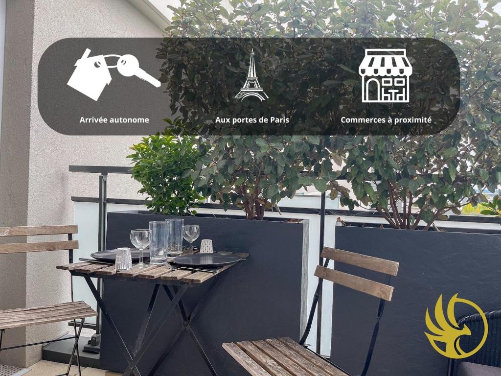 - une table avec des verres à vin et une pancarte sur un mur dans l'établissement F2 Idéal aux Portes de Paris, à Alfortville