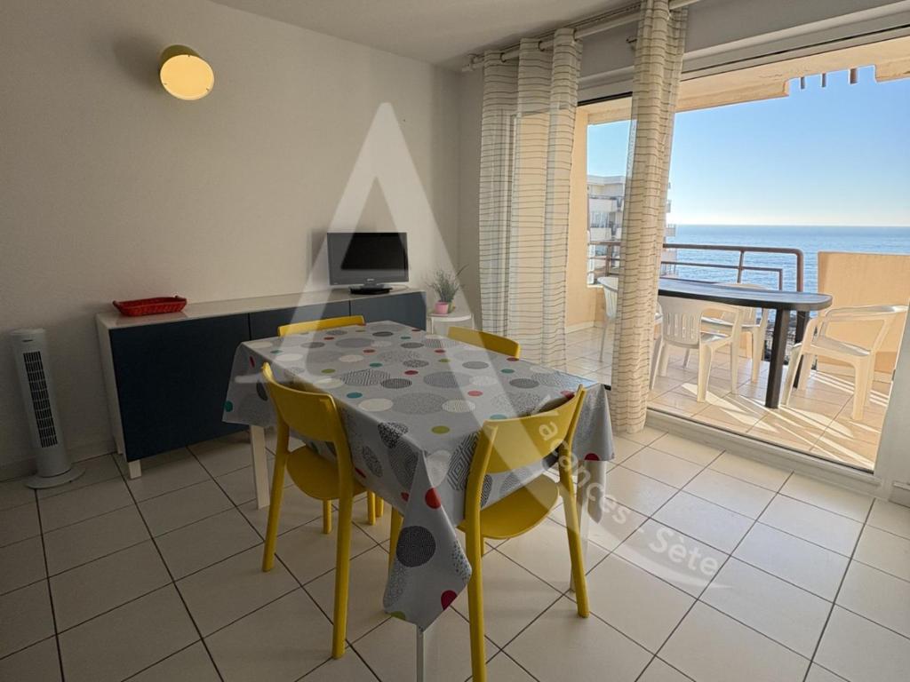 - une salle à manger avec une table et des chaises et une vue sur l'océan dans l'établissement 1 CHAMBRE, VUE MER, ACCES DIRECT PLAGE, à Sète