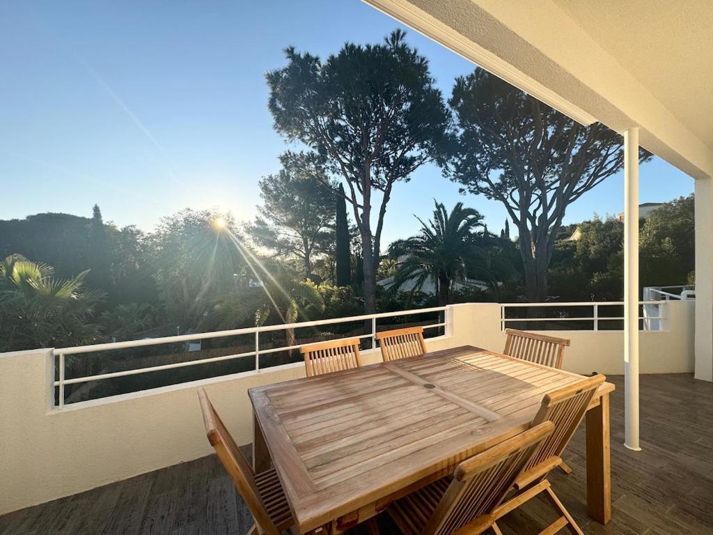 une table et des chaises en bois sur un balcon dans l'établissement Appartement 2ch avec terrasse à 400m de la plage, à Cavalaire-sur-Mer