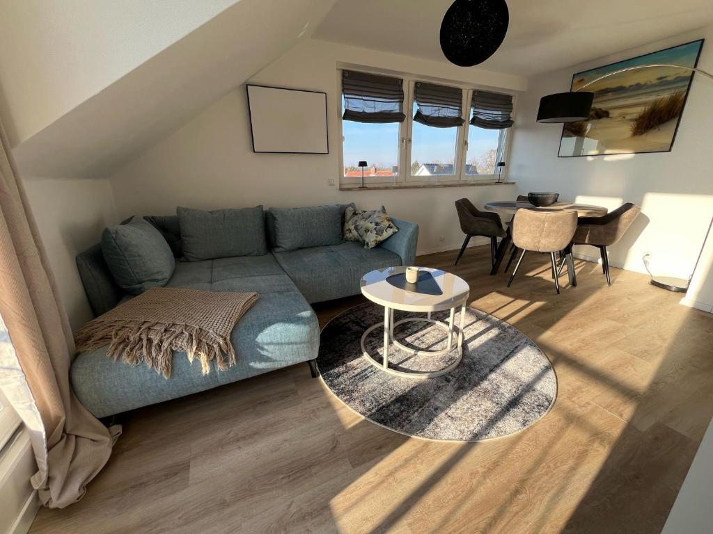 a living room with a blue couch and a table at Ostsee-AuszeitDahme in Dahme