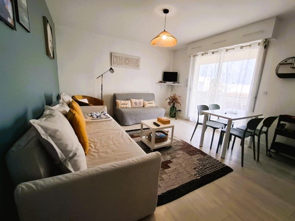 a living room with a couch and a table at Les Hauts de Perpigna in Royan