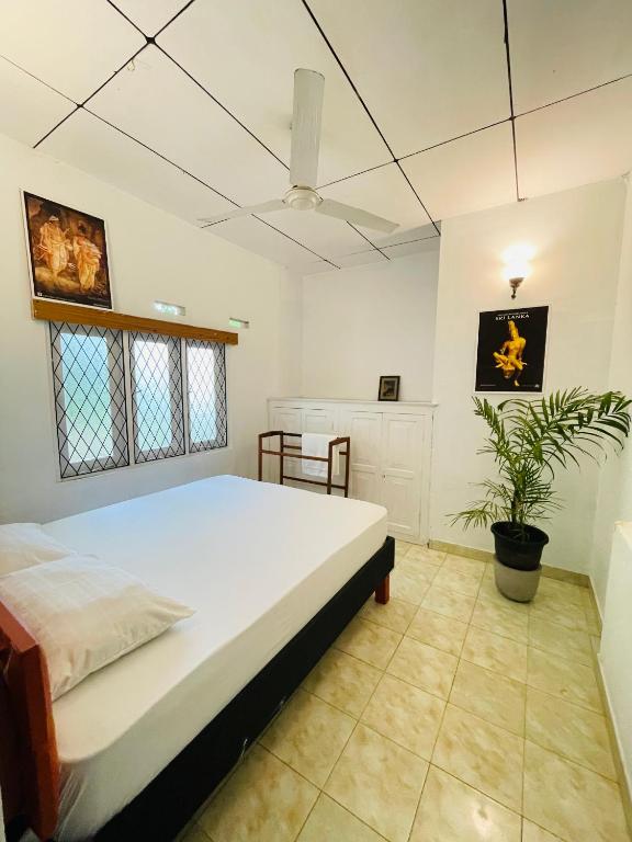a bedroom with a large bed and a plant at Gee Hills in Weligama