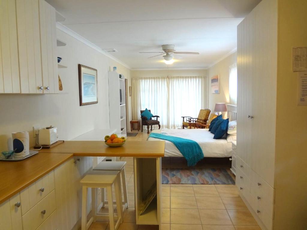 a kitchen and a bedroom with a bed in a room at Little Gem in Plettenberg Bay