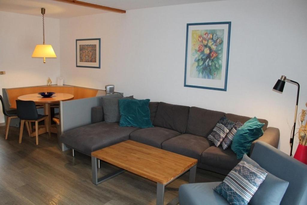 un salon avec un canapé et une table dans l'établissement Ferienhaus Nr 33, Kategorie Komfort, Feriendorf Hochbergle, Allgäu, à Lechbruck am See