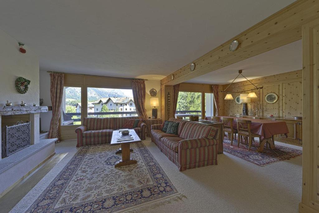 a living room with couches and a table and a kitchen at Chesa Pradash 5 - Celerina in Celerina