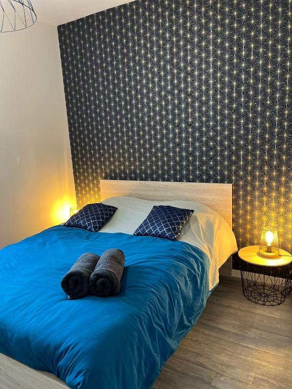 une chambre avec un lit avec des draps et des oreillers bleus dans l'établissement Appartement 1 chambre - Centre-ville, à Bourges