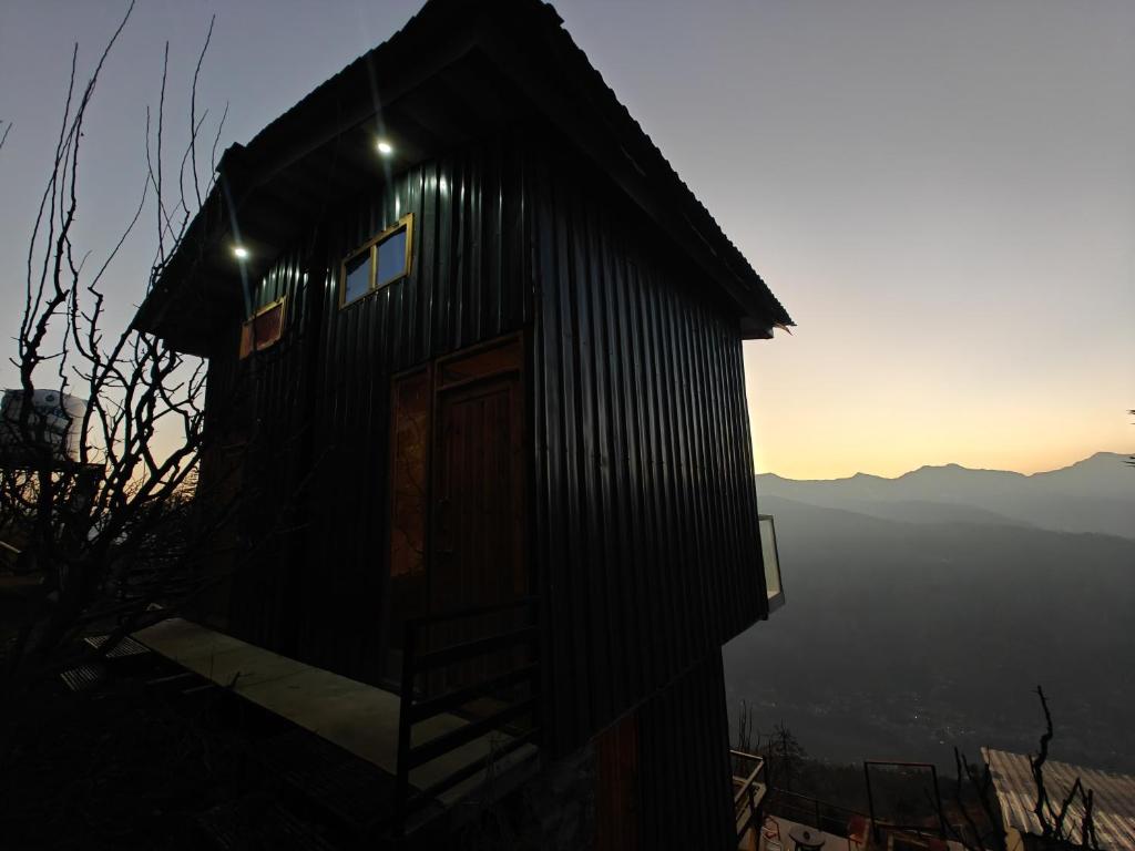 a small building with a door and lights on it at INFINITY OTH Cafe and Stays in Kulu