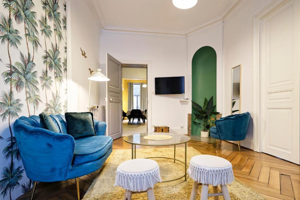 un salon avec un canapé bleu et une table dans l'établissement La Maison d'Annie - A 10min de la place Stanislas, à Nancy