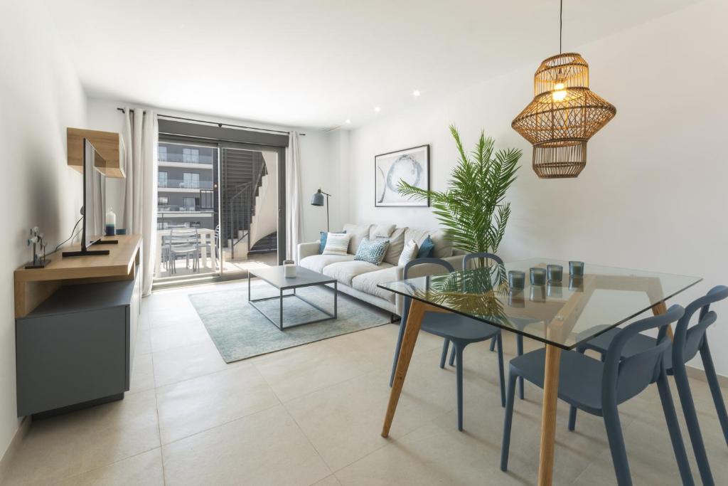 a living room with a glass table and a couch at AG El Alamo in Playa de Gandia