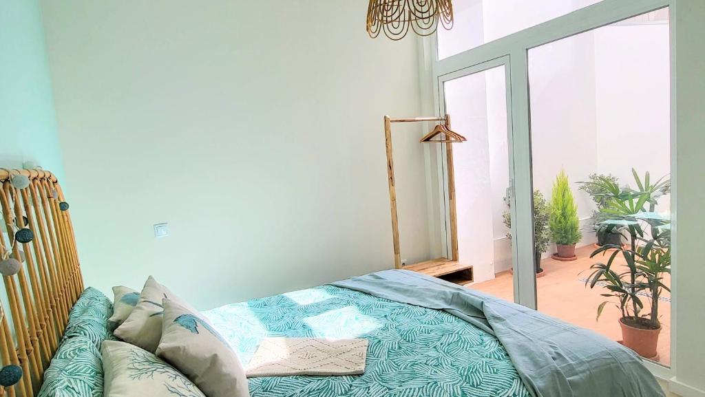 a bedroom with a bed in a room with plants at The Shore at Seaside Paradise - Cozy Patio on the Promenade in Espinho