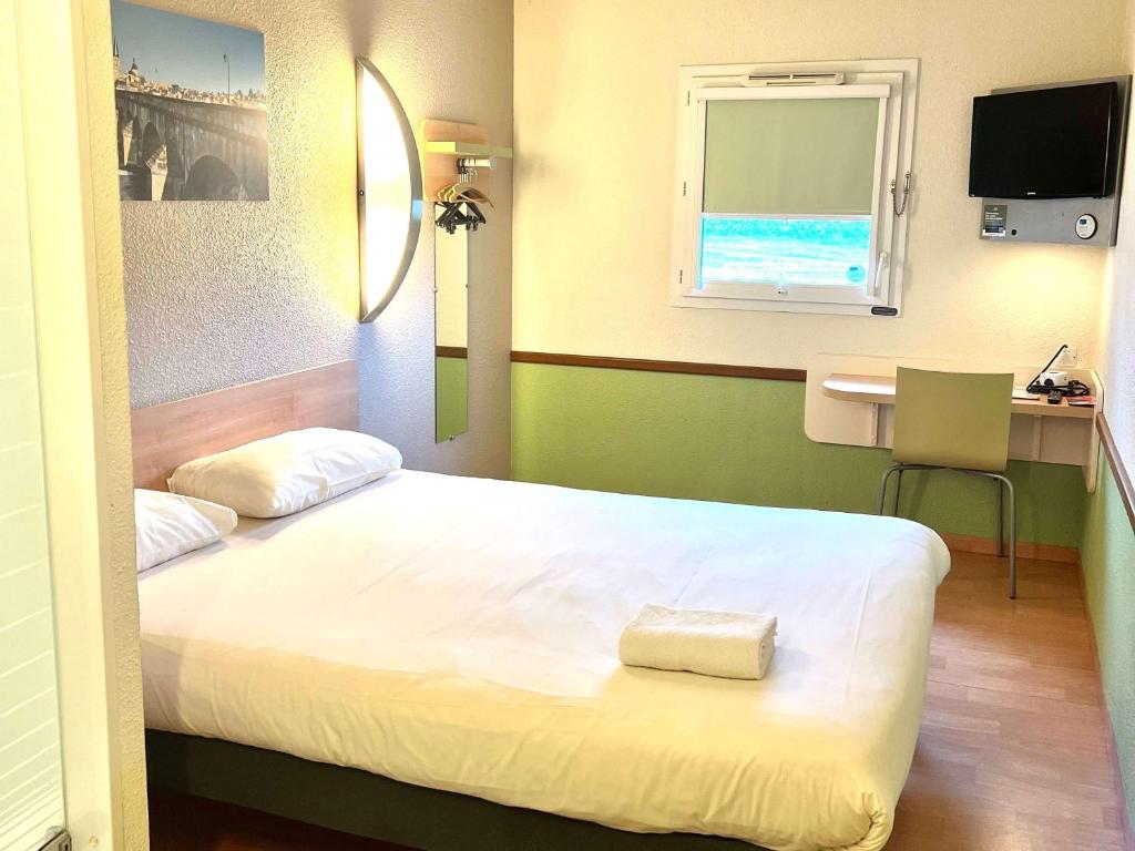 a bedroom with a bed and a desk and a window at Hotel Ibis Budget Cosne Sur Loire in Cosne-Cours-sur-Loire