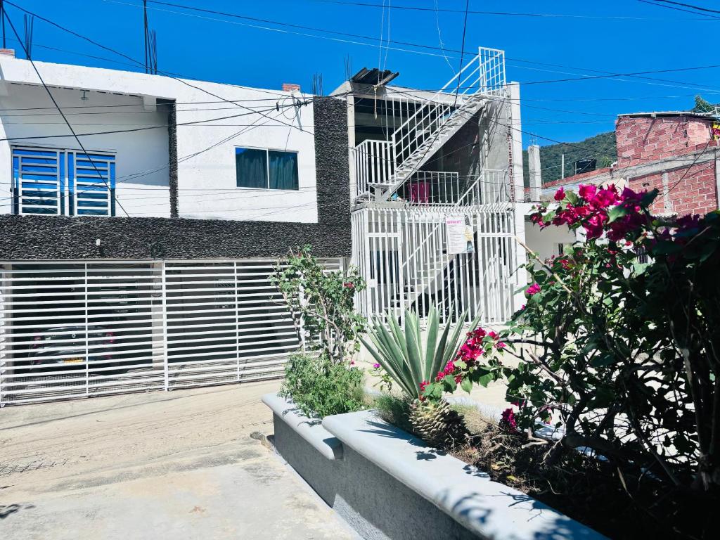 a building with a fence and some plants and flowers at Apartamento en Taganga in Taganga