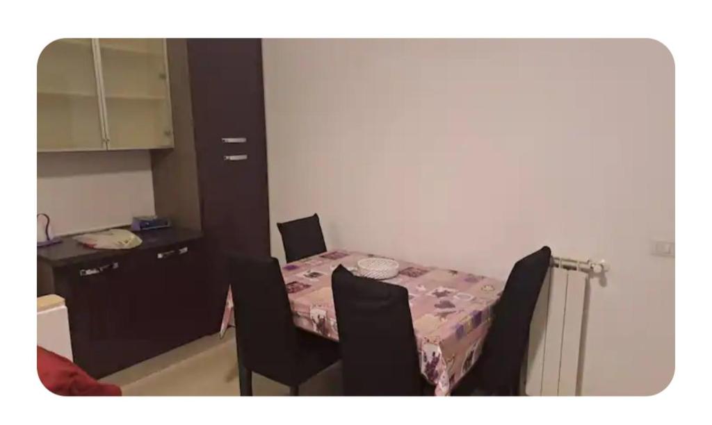 a room with a table and chairs and a kitchen at La tana del gladiatore 67 in Rome