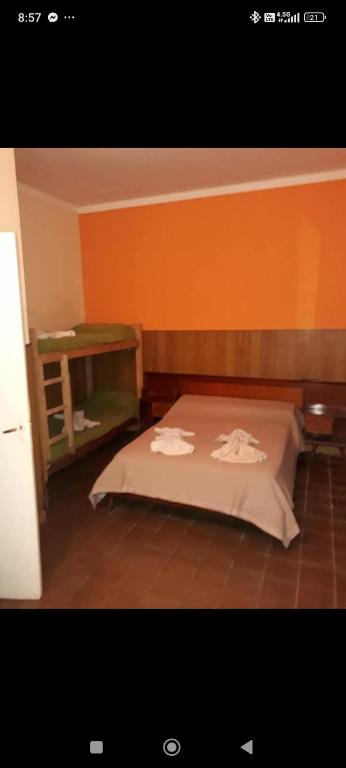 a bed in a room with an orange wall at Hotel Cuatro Soles in Mar del Plata