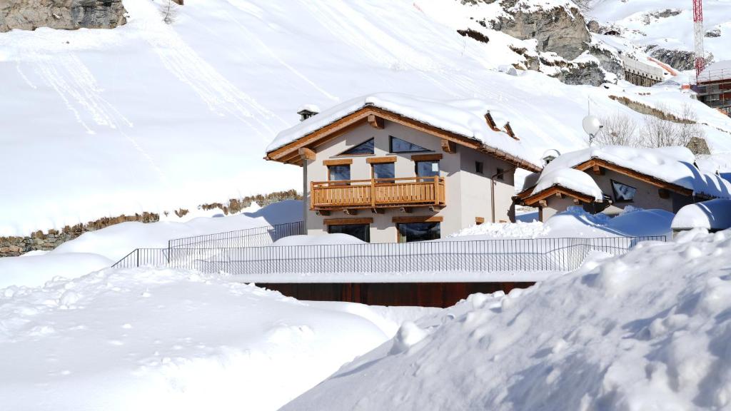 a house is covered in snow at Les Chalets de Rose in Breuil-Cervinia