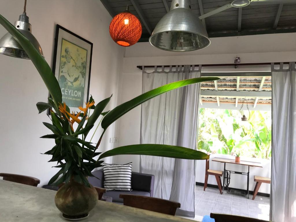 a dining room with a table with a plant in a vase at Villa Krish in Galle