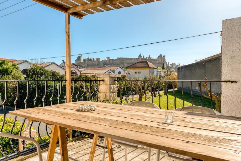d'une table en bois sur un balcon avec vue. dans l'établissement La maison Auguste - vue imprenable sur la Cité, à Carcassonne