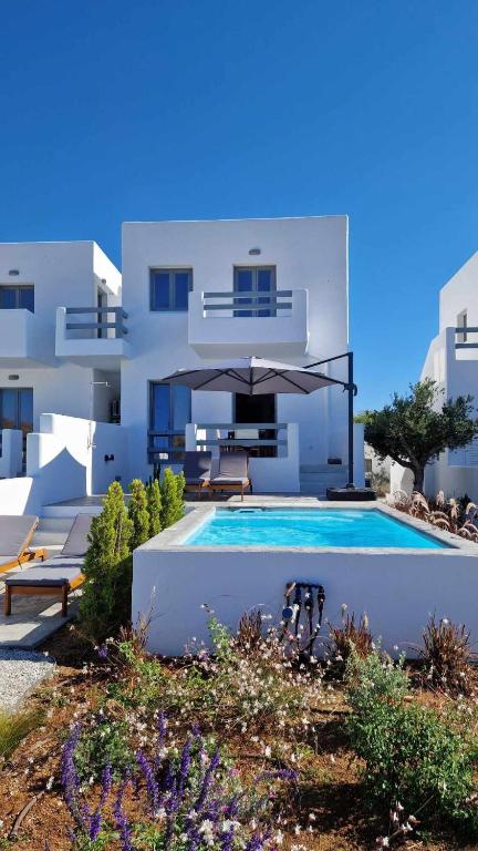 a white house with a swimming pool in front of it at Villa Meraki in Kastraki