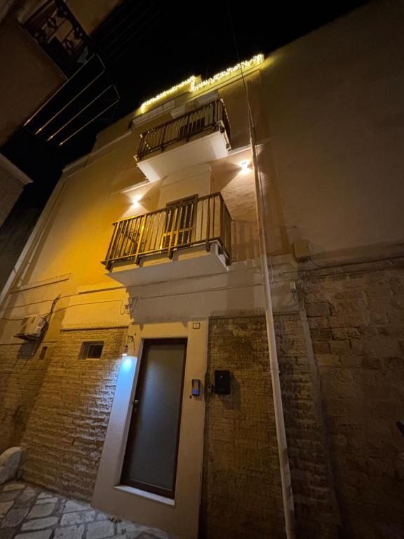 Un edificio con un balcón y una puerta por la noche. en HOME N & C Noemi & Costa, en Bari