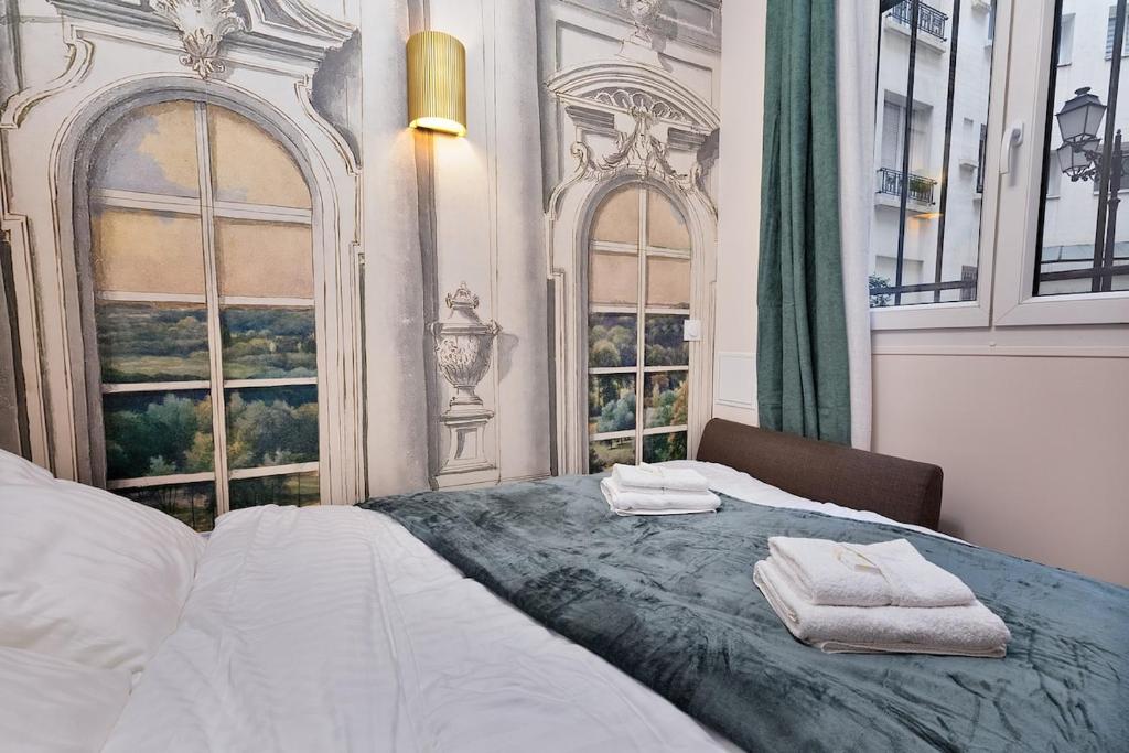 une chambre avec un lit avec deux serviettes dessus dans l'établissement Sophie Stay Montorgeuil -2BR 6P Wi-Fi, à Paris