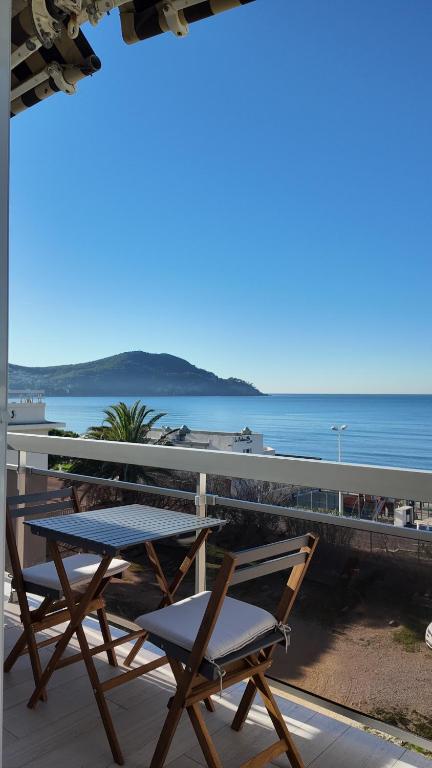 une table et des chaises sur un balcon donnant sur l'océan dans l'établissement Appartement cosy en bord de mer, aux Lecques