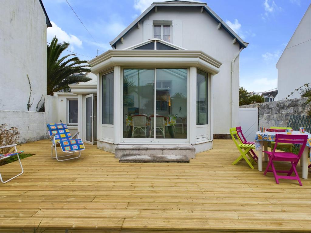 a patio with colorful chairs and a table at À 110 m de la plage, maison pour 6 personnes in Concarneau