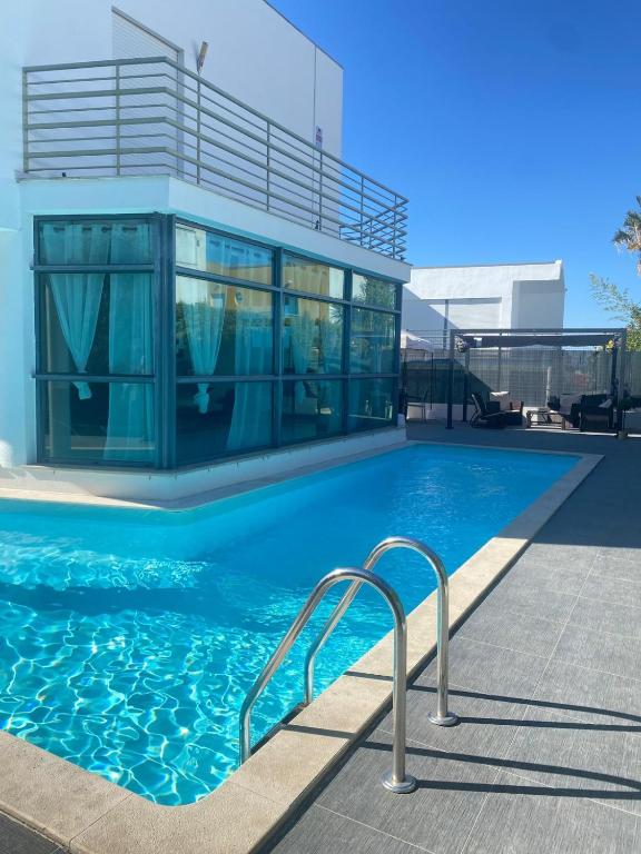 a swimming pool with a building in the background at Great V4 Villa with Private Salt Pool in Quinta do Anjo
