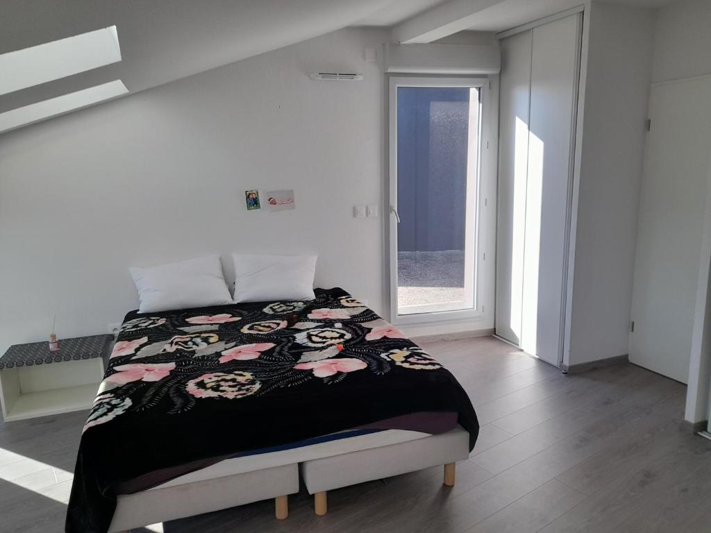 une chambre avec un lit avec une couverture noire et blanche dans l'établissement L'étoile, à Toulouse