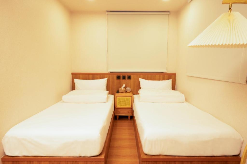 Postel nebo postele na pokoji v ubytování Cat Tail Pocket Inn Ximen