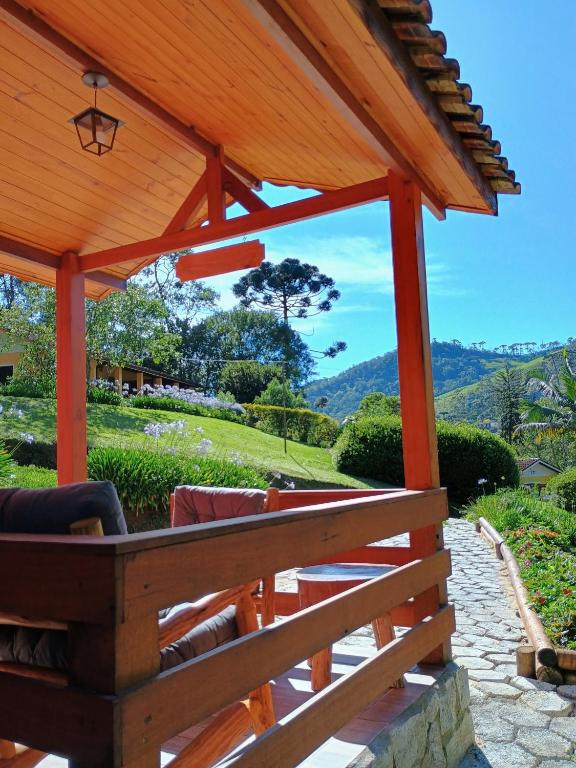 a wooden pergola with a view of the mountains at Chalé Recanto in Visconde De Maua