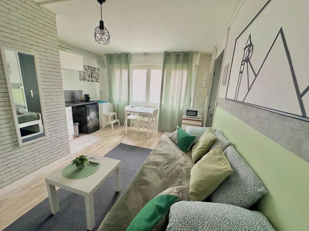 a living room with a couch and a table at Terrils jumeaux, Train Lens - Paris trajet d'environ 1 heure 10 minutes in Lens