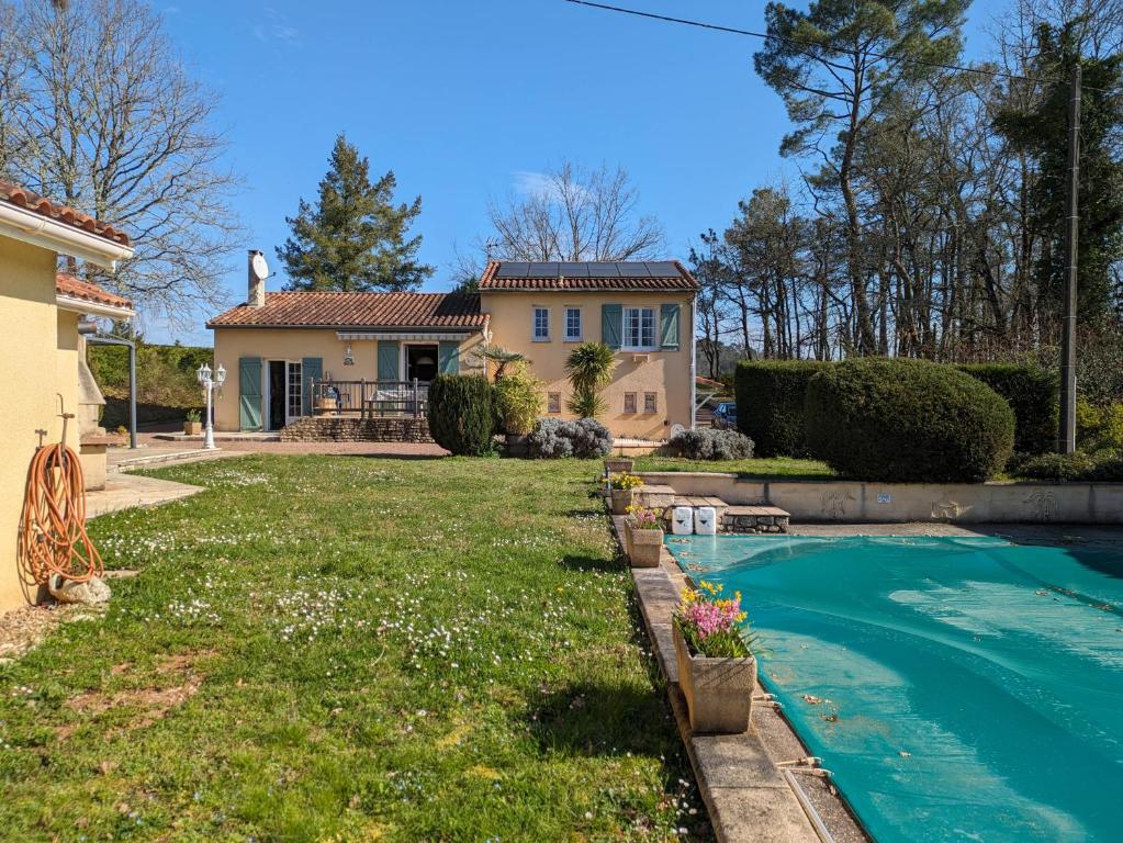 une maison avec une piscine en face d'une cour dans l'établissement Gite Le Petit Wren - avec piscine et vue, à Fumel