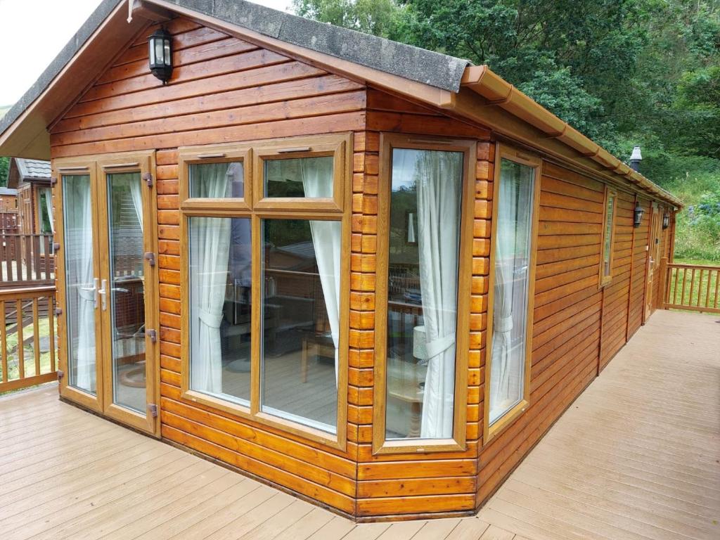 a wooden cabin with windows on a deck at 2 Bed Lodge-Sleeps 4-Valley View-Pet Friendly in Windermere