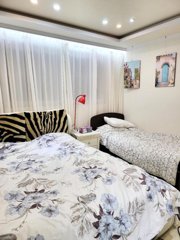 a bedroom with two beds and a window at Wonju Aunt Home in Wonju