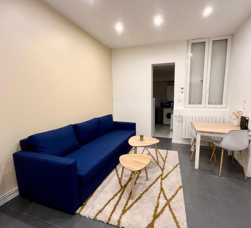 un salon avec un canapé bleu et une table dans l'établissement Dalikyda - Le Clovis - Central, au Havre
