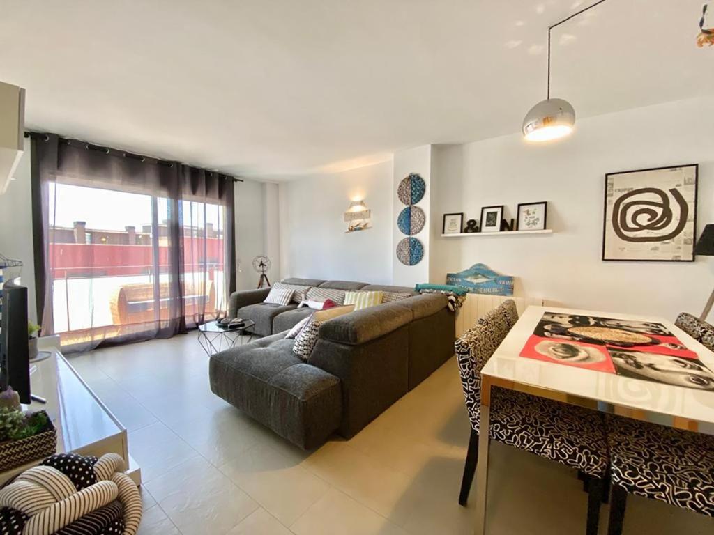 a living room with a couch and a table at LLOGUER30 El Far, swimming pool and parking in Sant Feliu de Guixols