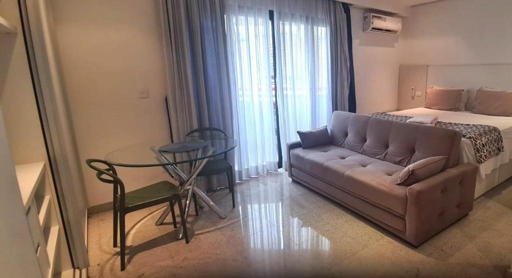 a living room with a couch and a bed and a table at Bienal Suites Ibirapuera c/ Sacada - UH 1207 in São Paulo