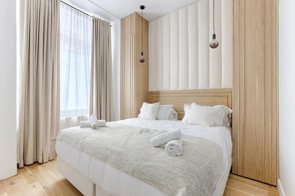 une chambre avec un grand lit blanc avec des serviettes dessus dans l'établissement Montparnasse - Modern & renovated 3BD for 8 guests, à Paris